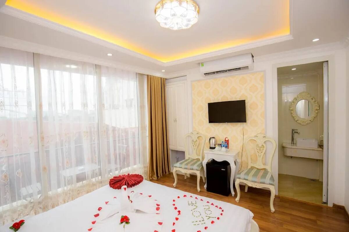 Une chambre d’hôtel comprenant un lit, une télévision, un bureau avec une chaise, un miroir et une salle de bain.