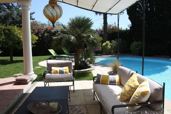 A poolside area with a covered patio, outdoor furniture, and a palm tree. - Superb luxury villa Orcivale Mougins - 4 bedrooms with swimming pool (Mougins)