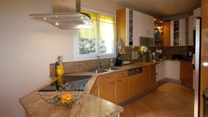 Una cocina moderna con encimera de granito, electrodomésticos de acero inoxidable y armarios de madera.