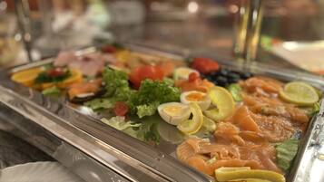 A buffet with various food items including salmon, eggs, and vegetables.
