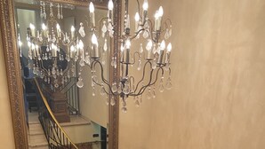 A grand staircase with a chandelier and a large mirror. - Hotel Villa Sophia (Warendorf)
