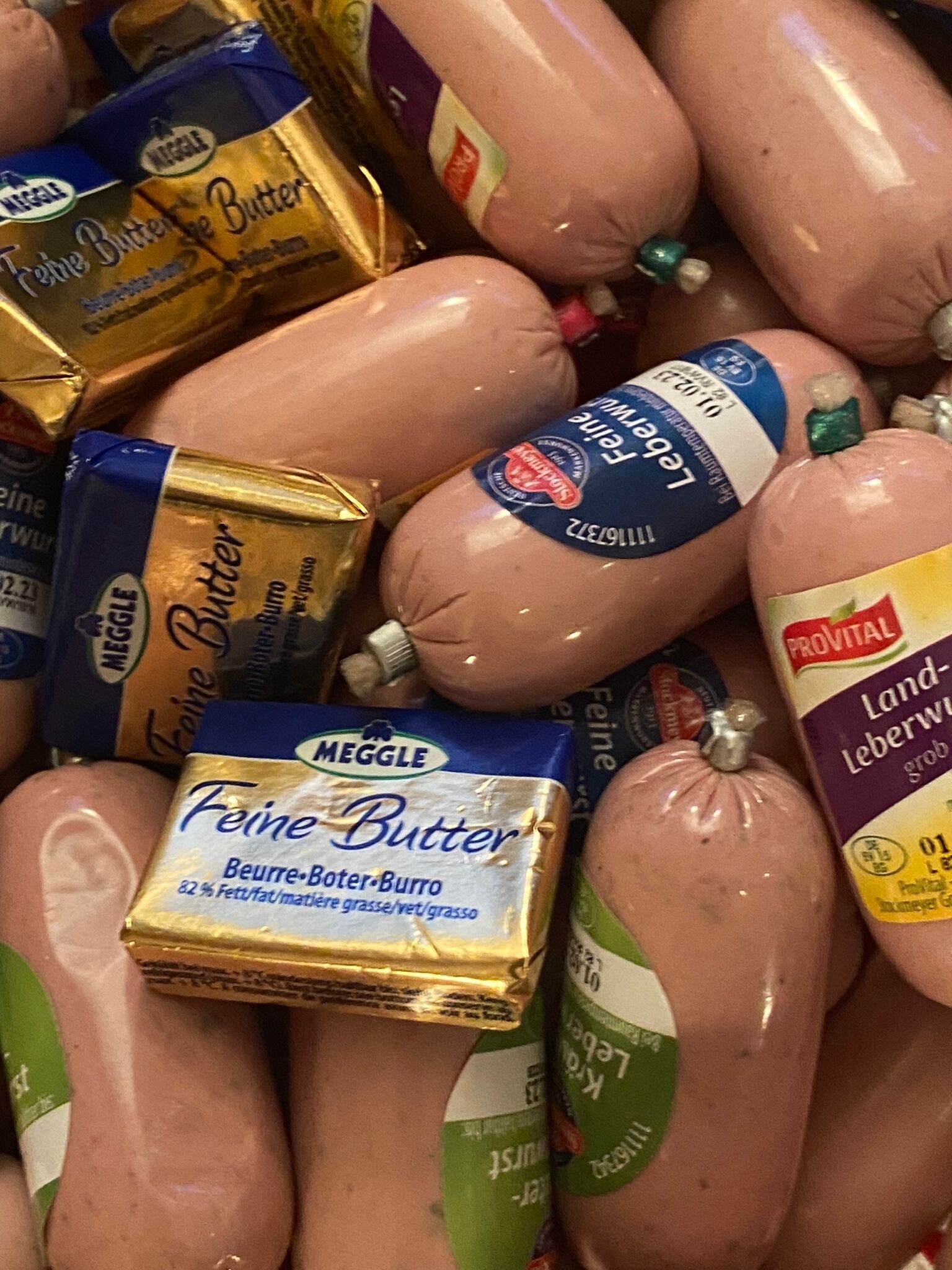 A pile of packaged sausages with visible brand labels.
