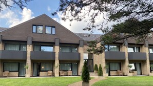 A multi-story building with a brick facade, large windows, and a paved courtyard with a brick pathway. - Hotel Villa Sophia (Warendorf)