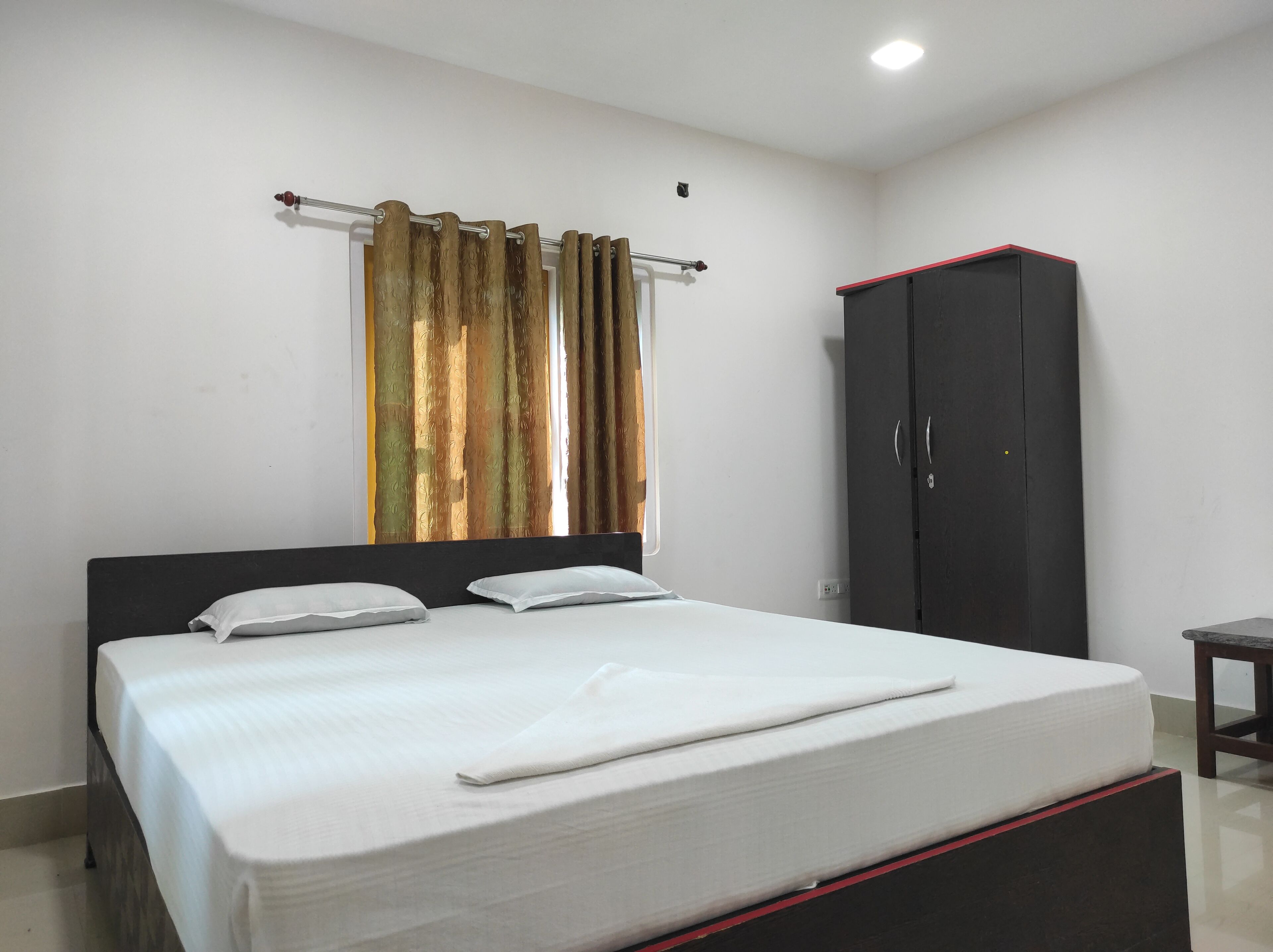 A bedroom with a bed, a wardrobe, and a curtain.