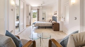 Un dormitorio moderno con cama, mesita de noche y una mesa de vidrio en el centro.