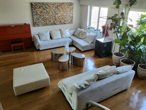 A modern living room with a sectional sofa, a coffee table, and a potted plant.