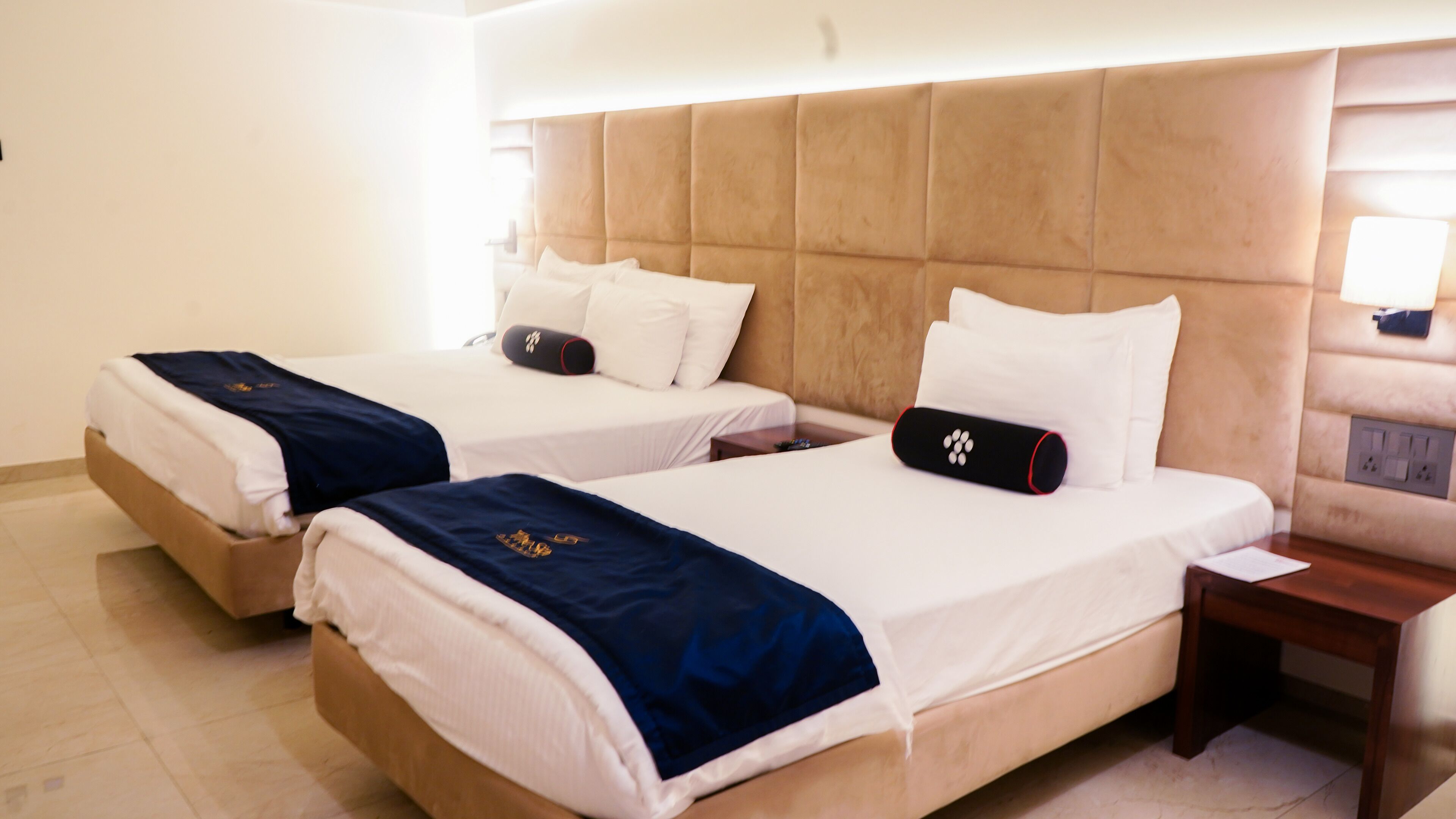 Two single beds with headboards, a bedside table, and a nightstand.
