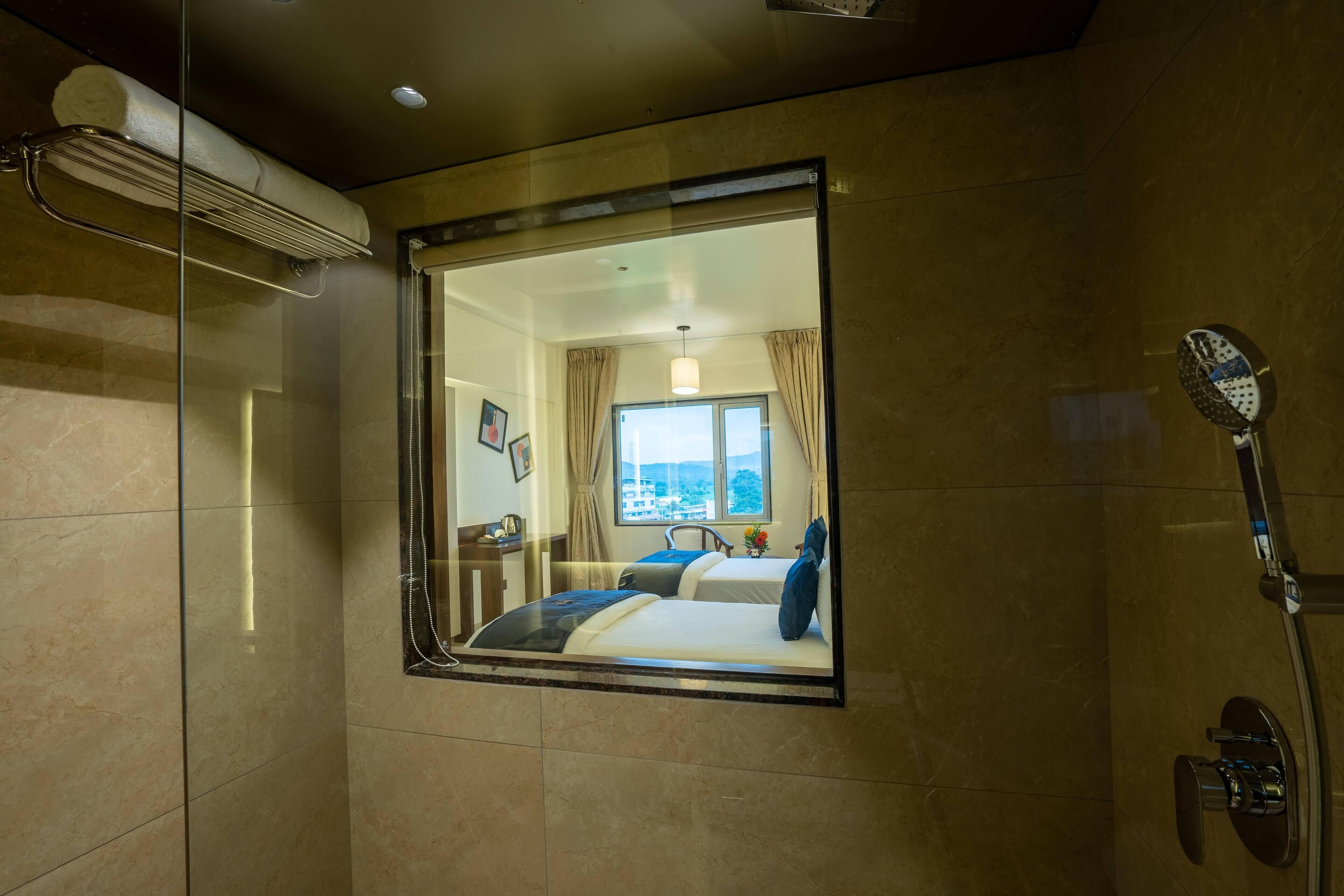 Une chambre d’hôtel dotée d’un grand miroir qui reflète le lit, la fenêtre et la salle de bain.