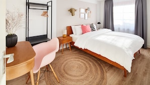 A bedroom with a bed, a desk, a chair, a small table, and a wall-mounted rack. - pop-up stuub bierhäusle feldberg (Feldberg)