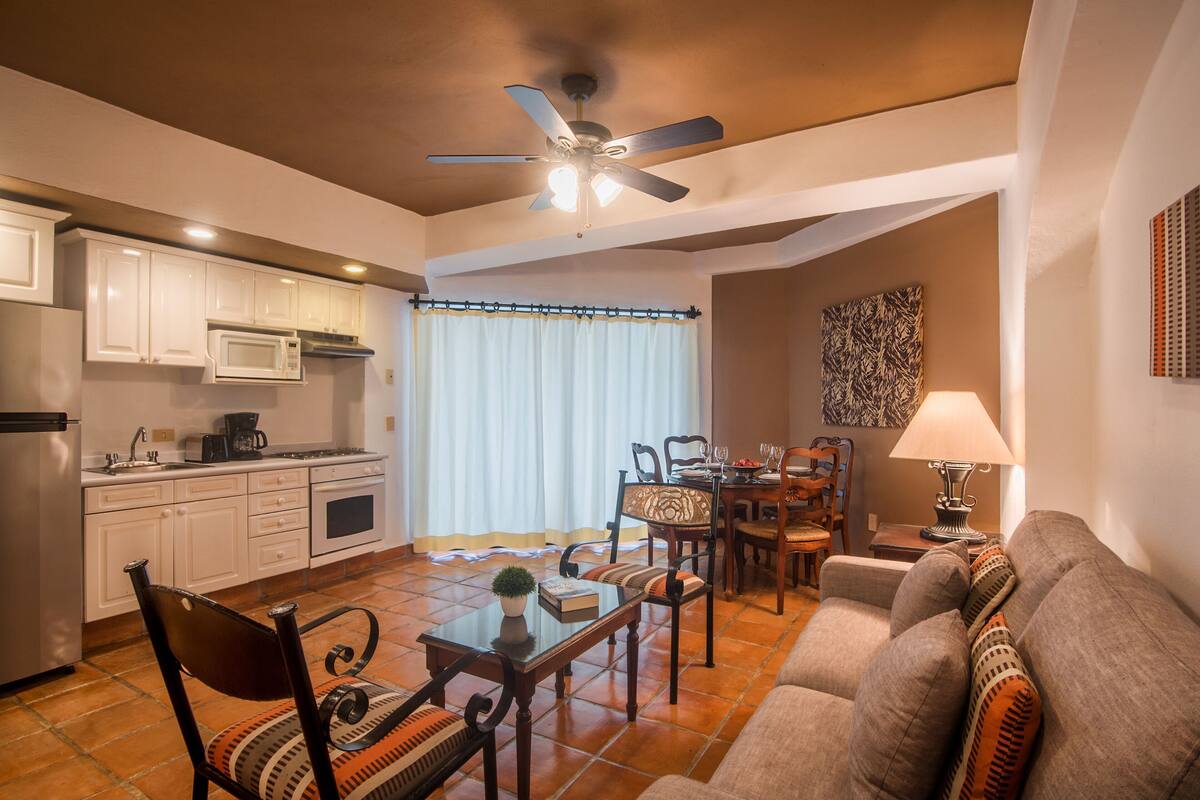 A compact living space with a kitchenette, dining area, and seating area.