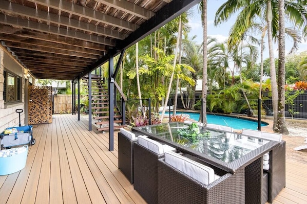 Relax in a serene outdoor oasis with a hot tub and pool surrounded by lush tropical vegetation.