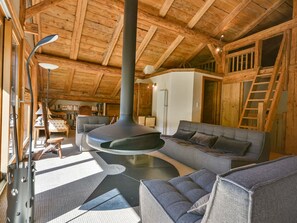 A cozy living room with a fireplace, wooden beams, and a comfortable seating area. - Modern chalet for 10 near slopes with parking and WIFI (Morzine)