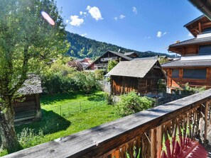 A wooden cabin with a sloped roof, surrounded by lush greenery and a clear sky. - Modern chalet for 10 near slopes with parking and WIFI (Morzine)