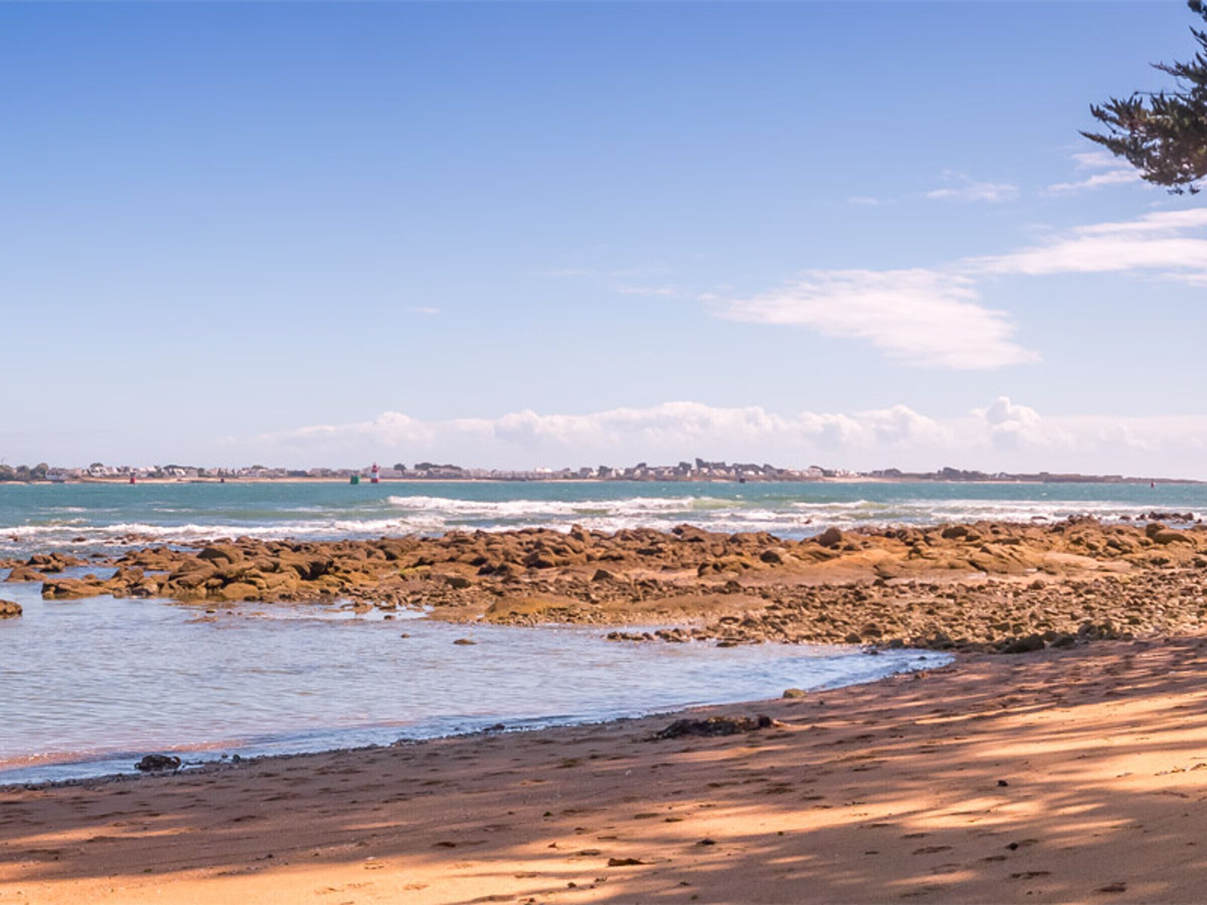 A beach with rocky shoreline and calm water.