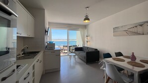 Une cuisine moderne avec vue sur la mer, un coin repas avec une table et des chaises, et un canapé.
