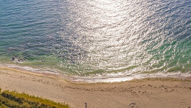 Une plage offrant une vue dégagée sur l’océan et bordée d’un rivage sablonneux.