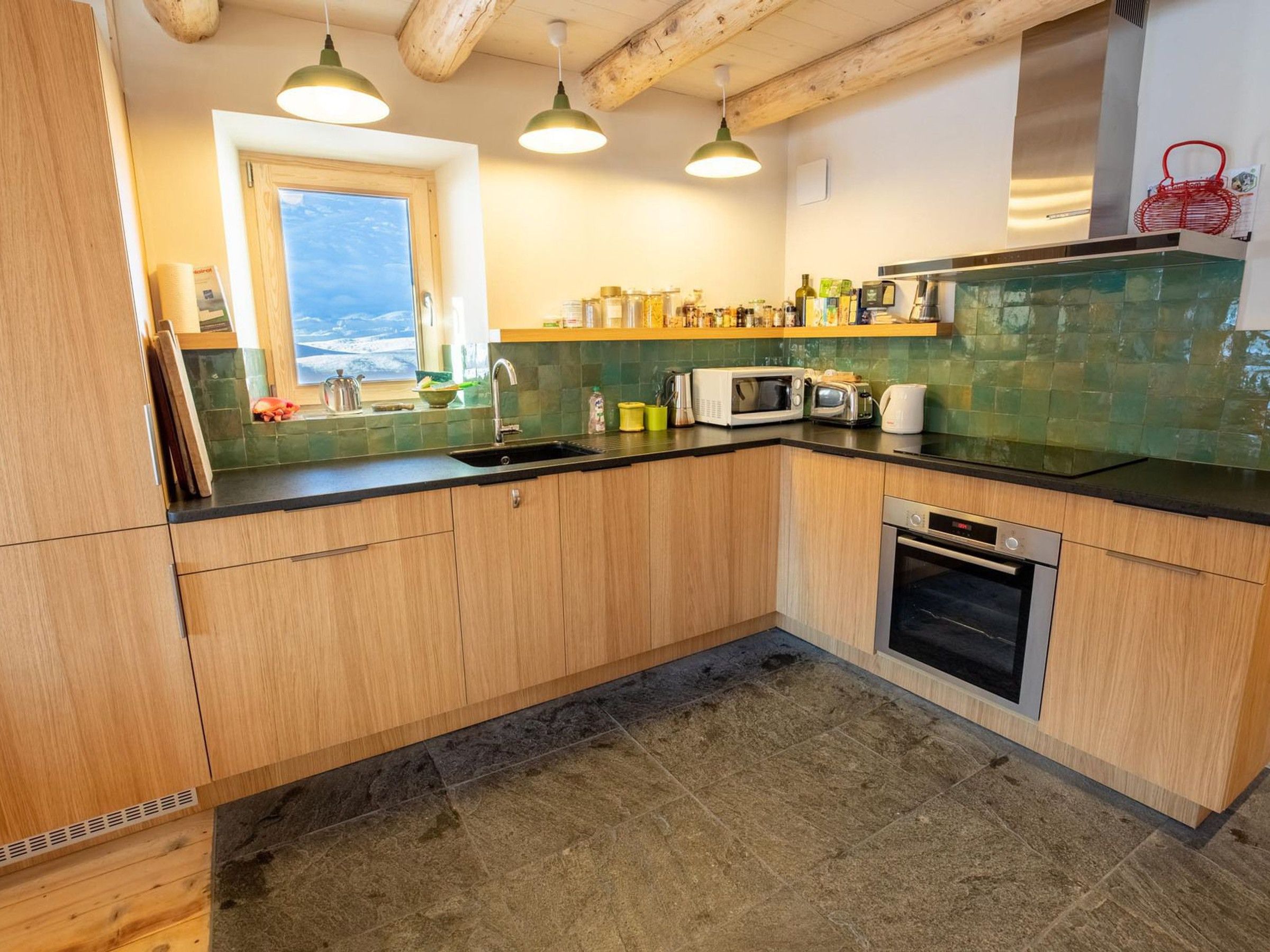Una cucina con mobili in legno, un forno a microonde, un tostapane e un lavello.