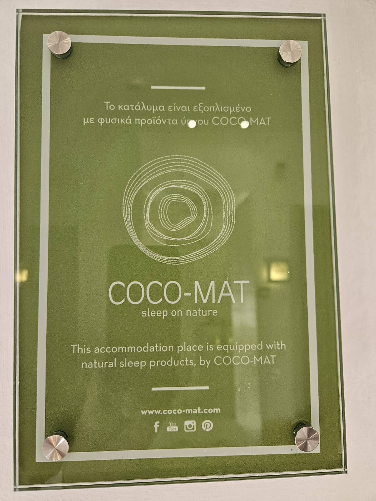A framed sign for COCO-MAT, promoting natural sleep products.