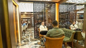 Un vestíbul d'hotel modern amb un sòl estampat, zones d'estar i separadors decoratius.
