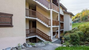 A multi-story building with wooden balconies and a stone pathway leading to the entrance.