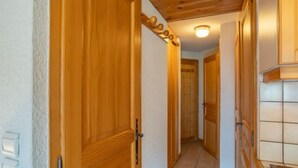 A hallway with wooden doors and a tiled floor.