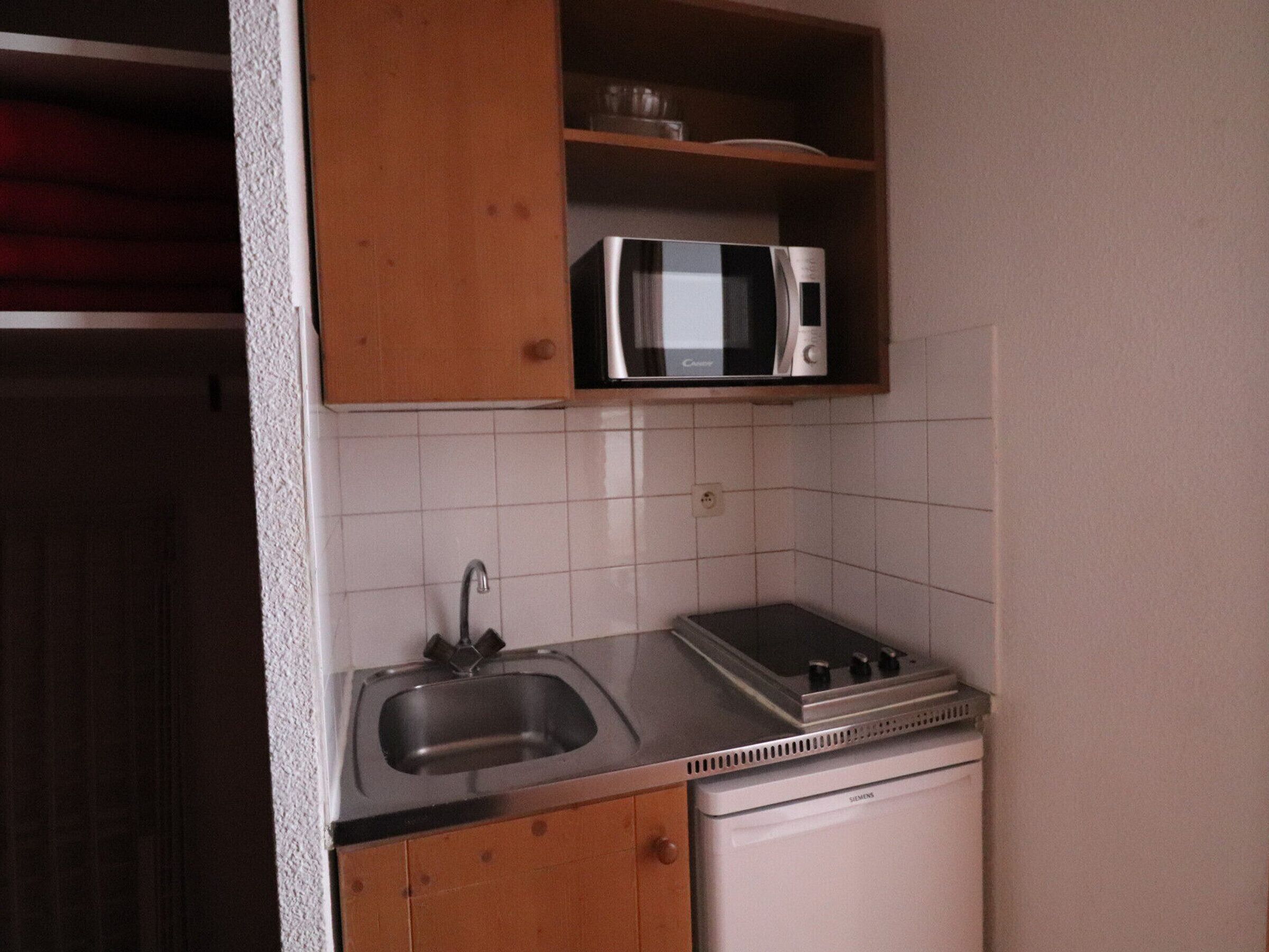 A compact kitchen with a sink, a microwave, and a dishwasher.