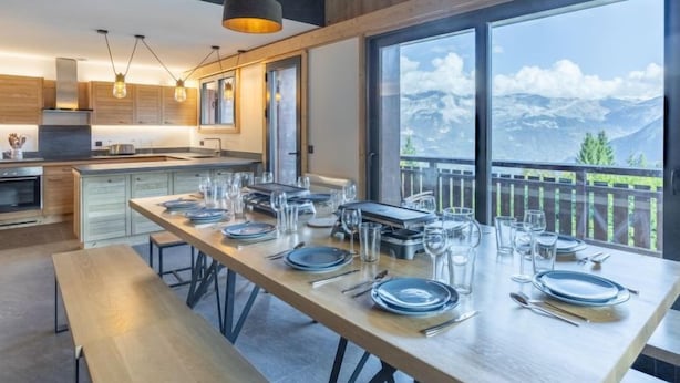 Una cocina moderna con armarios de madera, una isla grande e iluminación colgante.
