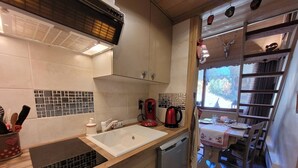 A compact kitchen with a sink, a coffee maker, and a dishwasher.