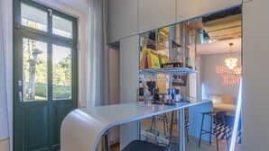 Une cuisine moderne dotée d’un comptoir incurvé, de tabourets de bar et d’un néon.