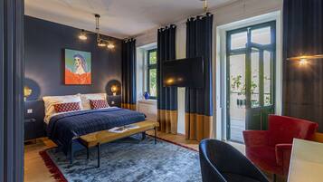 Un dormitorio moderno con cama, mesita de noche y televisión.