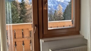 A room with a view of snow-capped mountains through a window. - PLOSE Parkhotel & Residence (Bressanone)