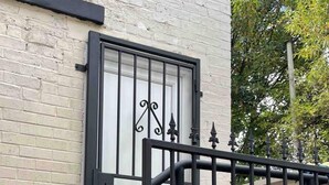 A black metal staircase with a white door and decorative elements. - Modern and Cosy Apartment in Leeds, England (Leeds)