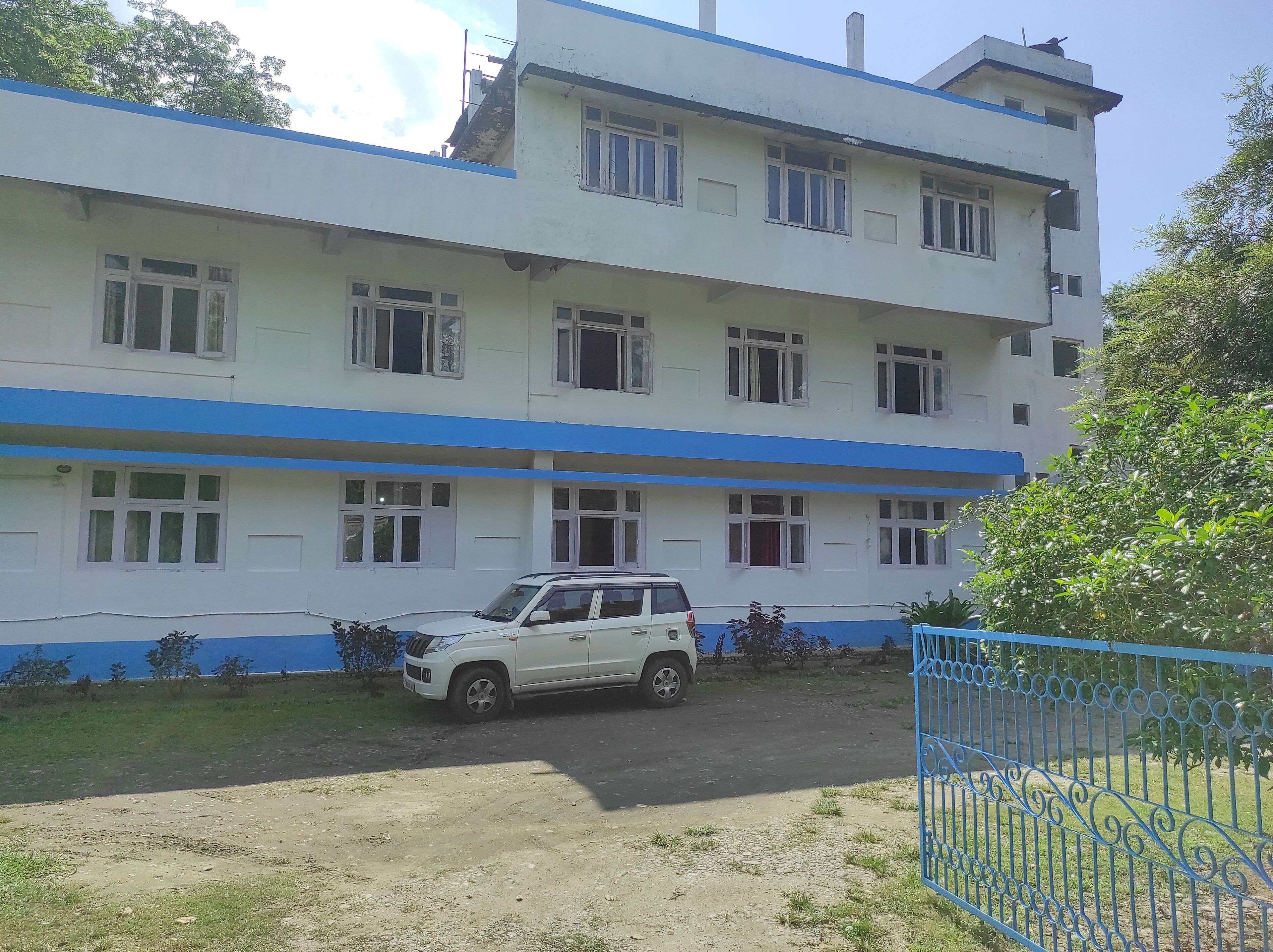 Un edificio de varios pisos con fachada blanca y detalles azules.