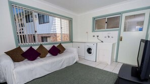Relax in this cozy space with a sofa, washing machine, and TV.