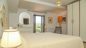 A bedroom with a bed, a bedside lamp, a mirror, a wardrobe, and a view through an open door. - Tranquility, relaxation? This is the right place. We'll be waiting for you!!! (Viterbo)