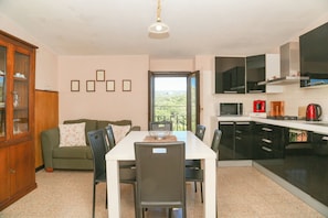 Una cocina moderna con comedor, sofá y vistas al exterior.