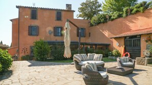 A patio with wicker furniture, a stone floor, and a building with a tiled roof and shutters. - Tranquility, relaxation? This is the right place. We'll be waiting for you!!! (Viterbo)