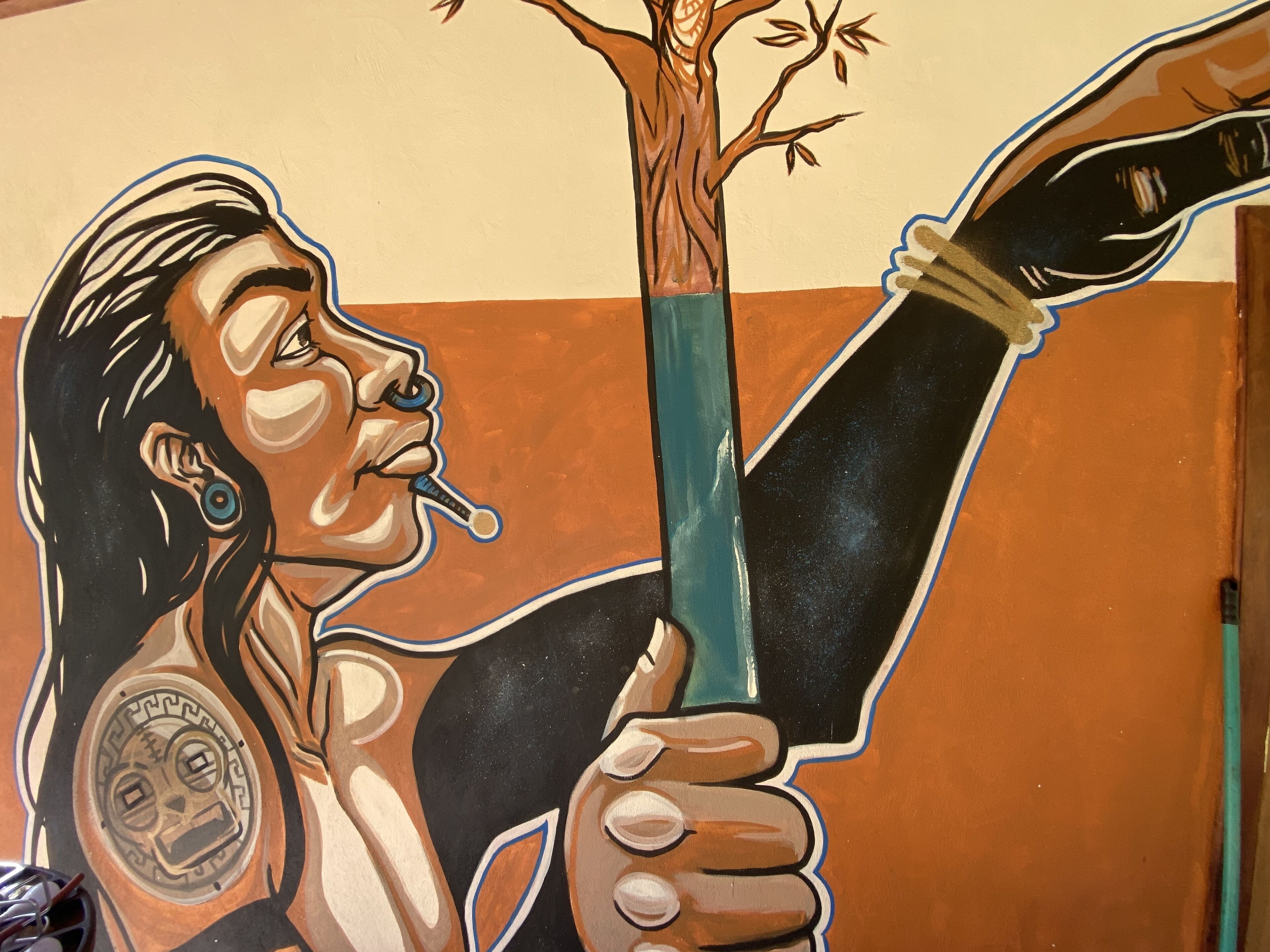 A mural with a person holding a tree.
