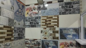 Casa de banho com parede de azulejos em mosaico representando diversas cenas e padrões da natureza.