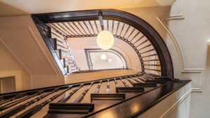 Uma escadaria imponente com design curvo e um lustre central.