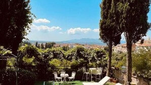 A rooftop pool area with a clear view of the cityscape, surrounded by greenery and equipped with lounge chairs. - Quattro Gigli Palace (Montopoli in Val d'Arno)