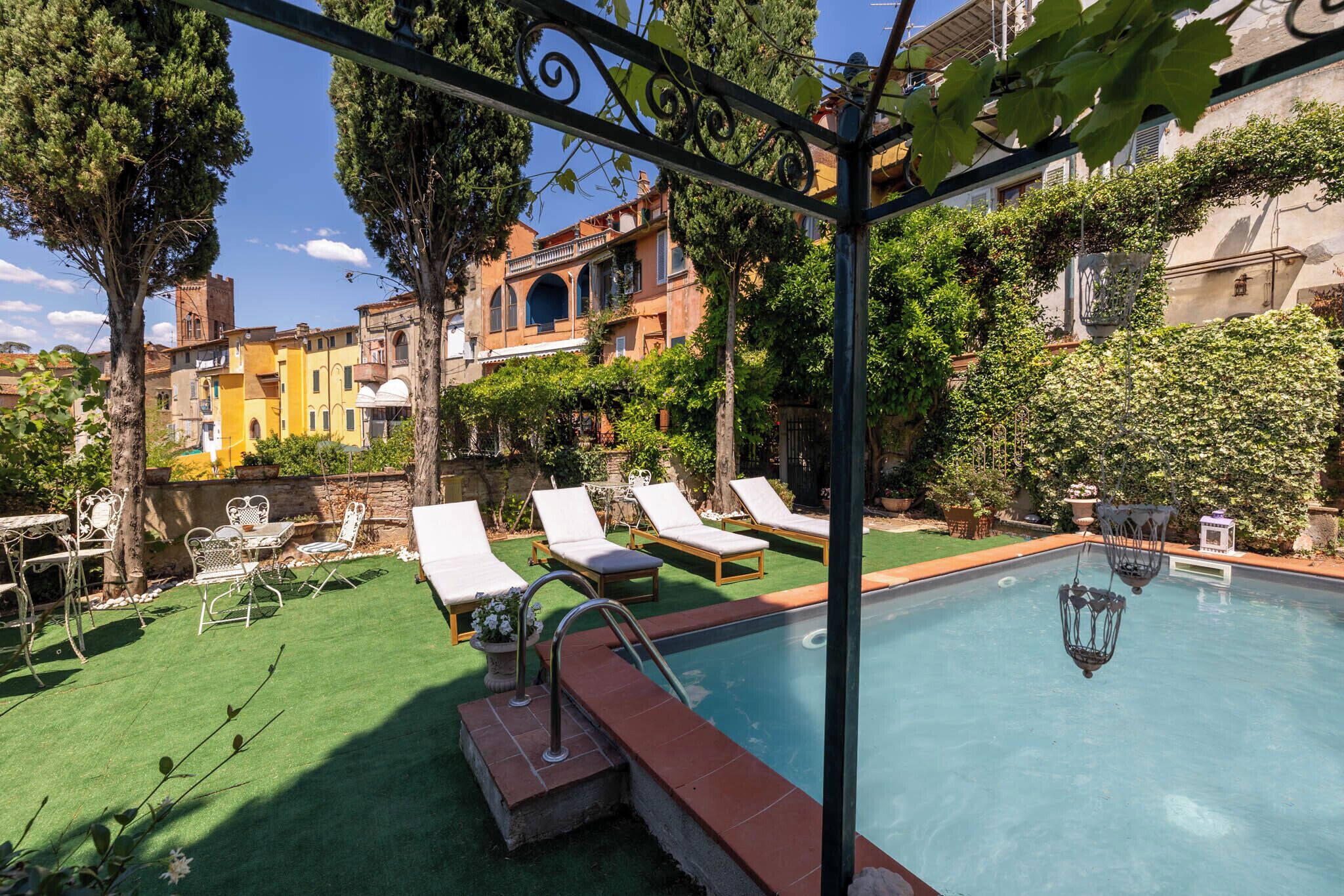 Ein Schwimmbecken mit Liegestühlen und einer Pergola.