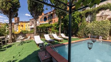 Ein Schwimmbecken mit Liegestühlen und einer Pergola.
