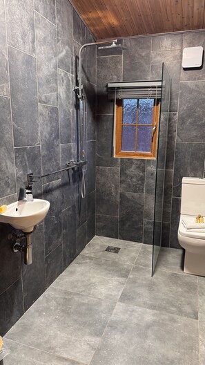 Ein Badezimmer mit Dusche, Waschbecken und Toilette.