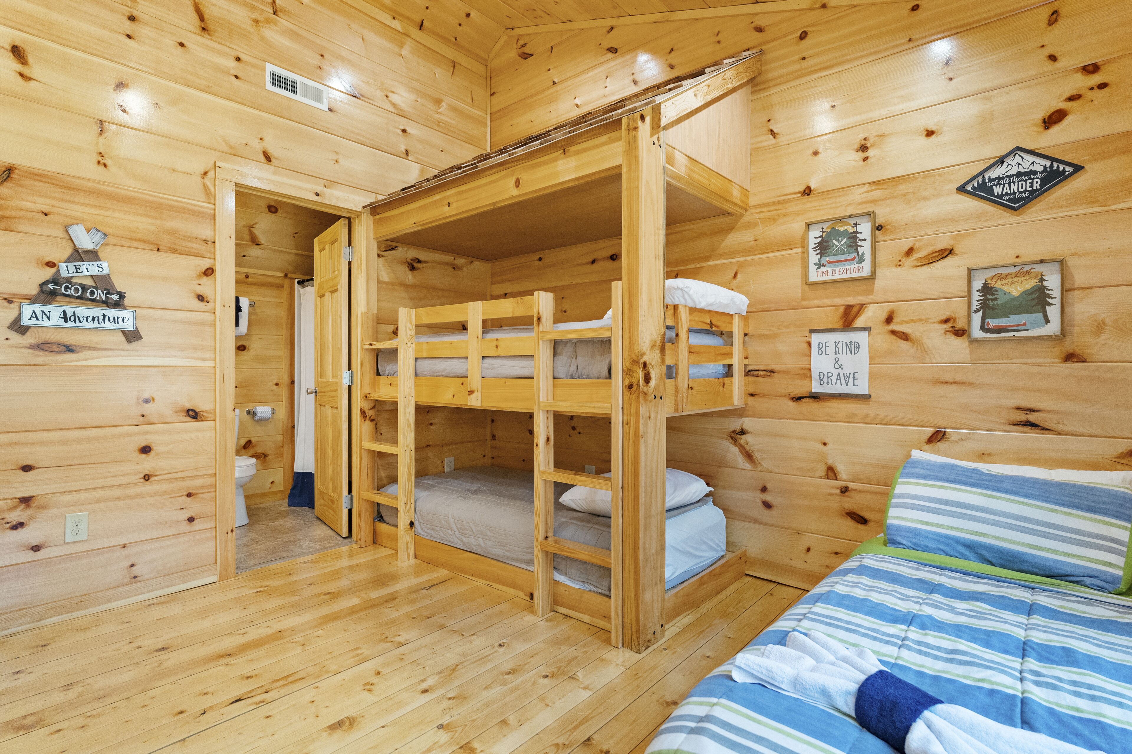 A cabin with bunk beds, wooden walls, and various motivational posters.