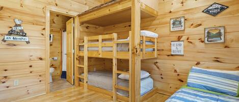 A cabin with bunk beds, wooden walls, and various motivational posters.