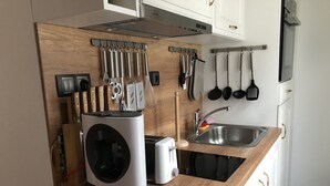 Una cocina con lavadora integrada, tostadora y pileta.