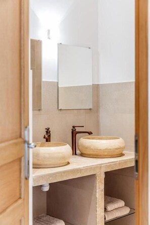 A bathroom with a wooden vanity, two sinks, a mirror, and a towel rack. - La Maison du Grand Bossieu (Bossieu)