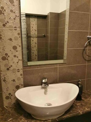 A bathroom with a white sink, a mirror, and a towel rack. - Modern Apartment Near the Beach in Cyprus (Polis)