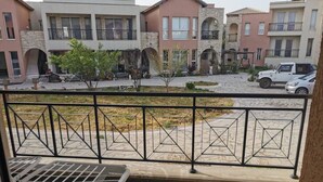 A balcony with a metal railing, a small table, and a chair. - Modern Apartment Near the Beach in Cyprus (Polis)